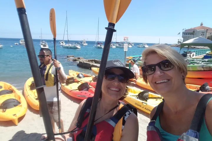 a woman holding a hot dog in a body of water