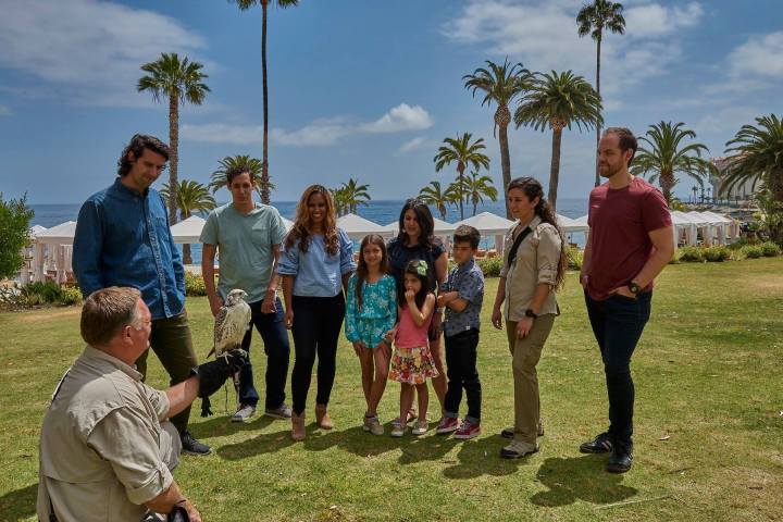 a group of people standing on top of a grass covered field