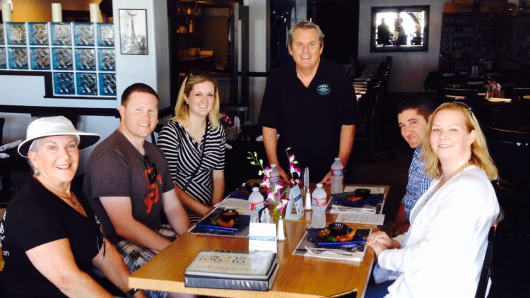 a group of people sitting at a table posing for the camera