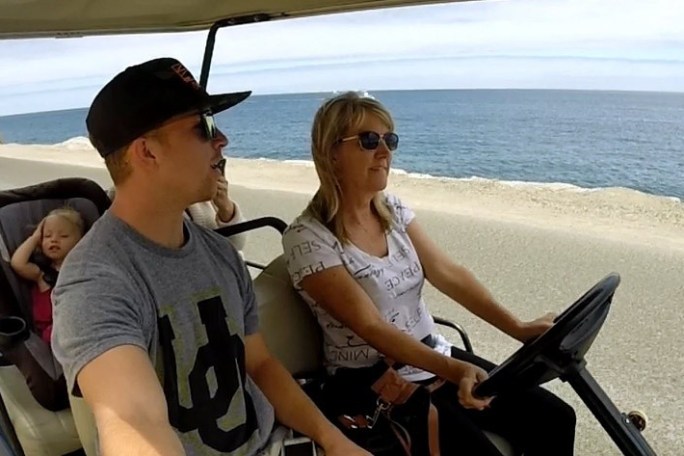 a woman sitting on a bench next to a body of water