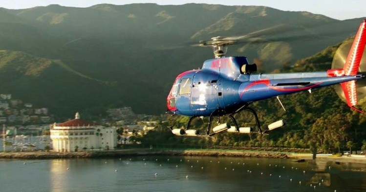 Maverick Helicopters a plane flying over a body of water
