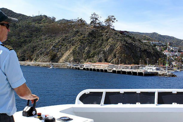 a man riding on the back of a boat in the water