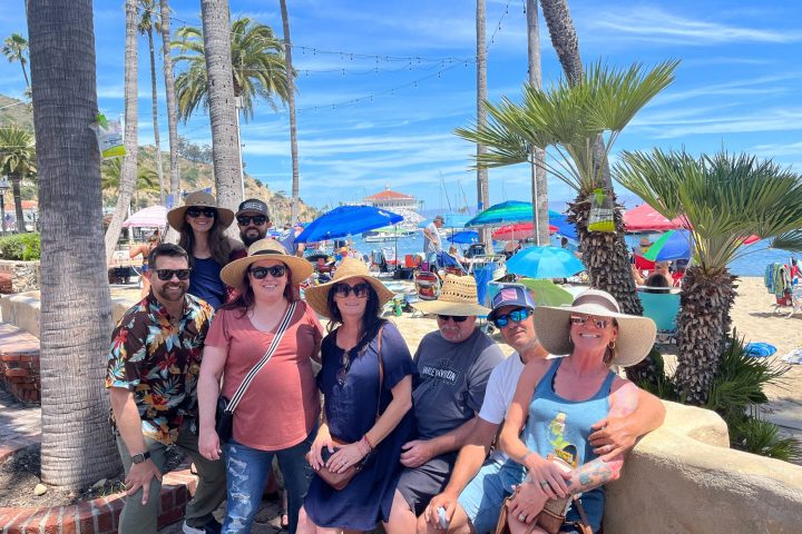 a group of people at the start of the Catalina Food Tour on the serpentine wall in Avalon, CA