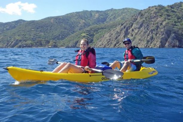 a man riding on the back of a boat in a body of water