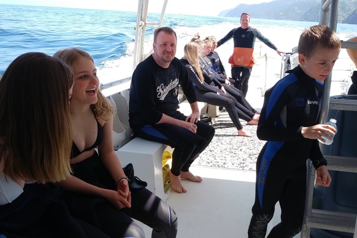 a group of people sitting on a boat in the water